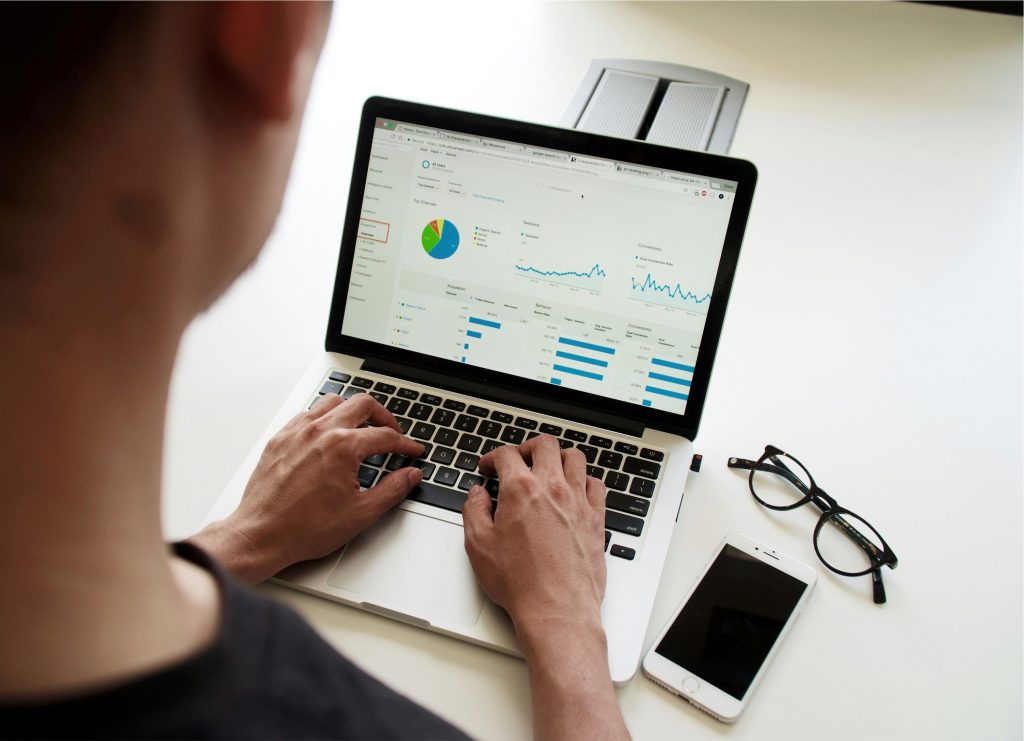 man on laptop with graphs displayed