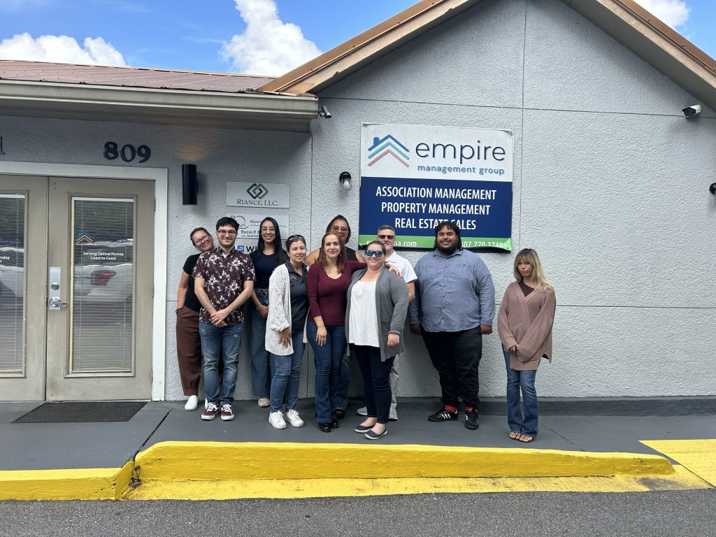 Empire Management Group Kissimmee team in front of their office, offering HOA and condo management services in Central Florida.