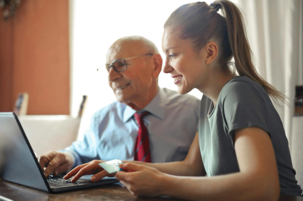 Smiling residents making an online HOA or condo payment on a laptop.