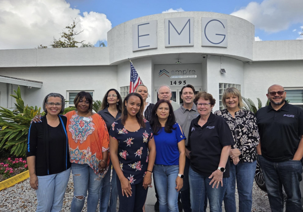 Empire Management Group HOA and condo management team in Florida standing in front of EMG office.