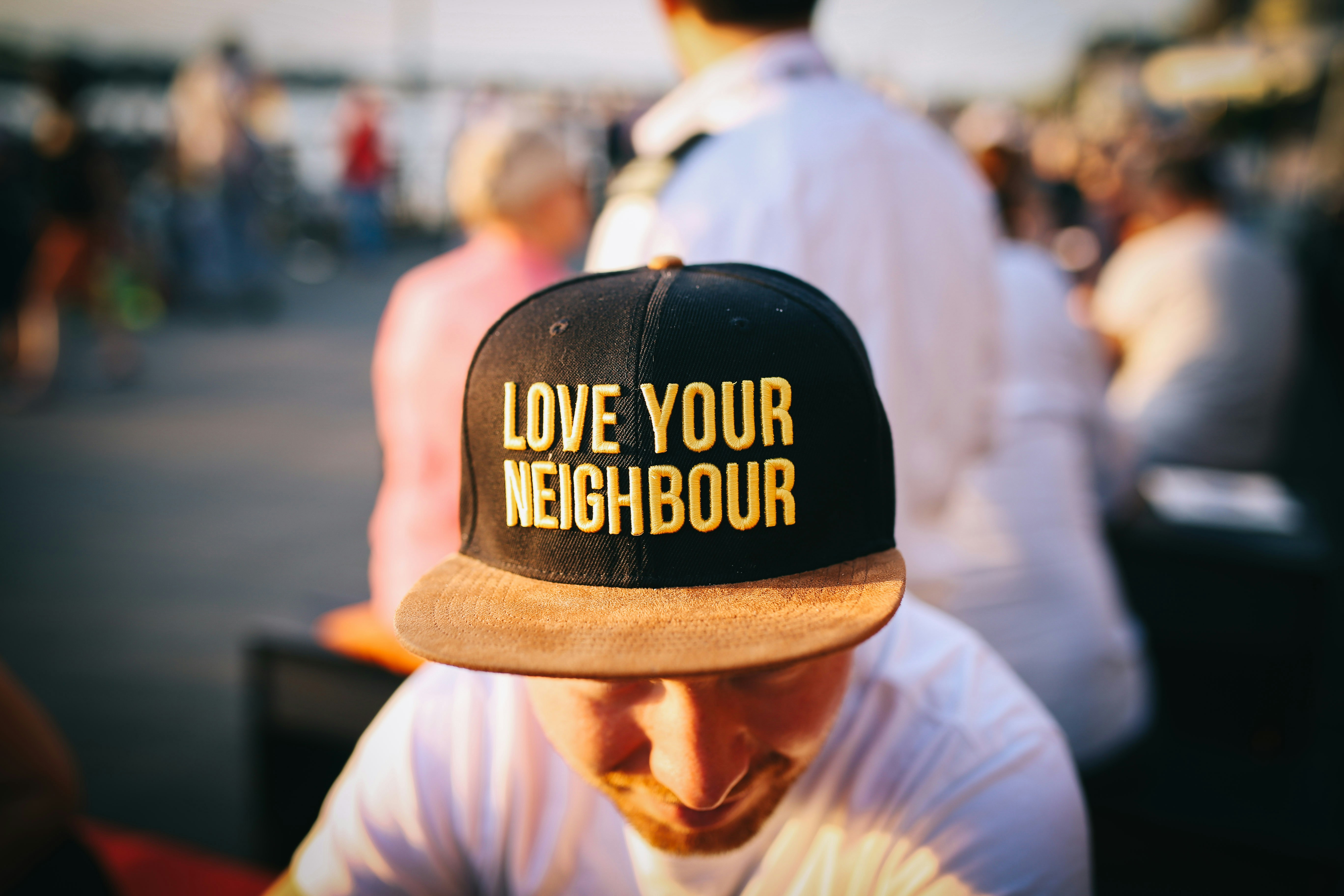 man wearing a love your neighbor hat